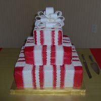 Present Wedding Cake This was my second wedding cake I've done. It is iced in red buttercream with white fondant ribbons to resemble a present. It was very...