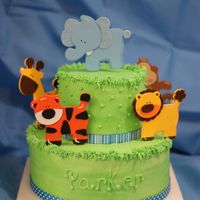 Baby Shower- Animal A 2-tier Jungle theme baby shower cake. BC icing, ribbon around the bottom of the tiers & wooden cutouts of animals that I found. I...