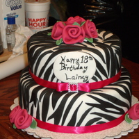 Fushia, Black And White Zebra Cake 18th Birthday cake. White with black zebra stripes and fushia ribbon roses. 8 inch top tier and 10 inch bottom tier, chocolate cake with...