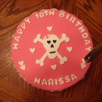 Scull And Crossbones Cake Pink fondant covered cake with fondant decorations.