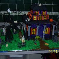 Haunted House Scary, spooky haunted house made of gingerbread walls and roof, candy graveyard figurines, and buttercream icing