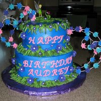 Tinkerbell Cake Chocolate cake and white cake tiers, with buttercream icing. Royal icing stars. The figurines on top are not edible, they were provided by...