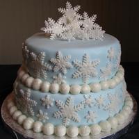 Blue With Snowflakes This is a two tier cake with blue fondant and gumpaste snowflakes.