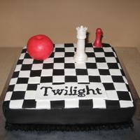 Twilight Cake is covered in fondant. Squares are individually places squares. The chess pieces were made from gumpaste. The apple is RKT covered in...