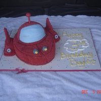 Rocket Oval pan with half of ball pan on top and twinkies for the side and cake board decorated with icing for the fin part.