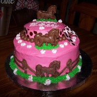 Childrens Horse Birthday Cake 2 tier yellow cake with buttercream icing. Chocolate candy horse molds and chocolate WHOPPERS candies around the middle tier.