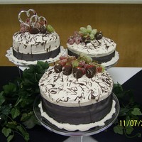 Anniversary Cakes 3 different cakes, all using buttercream frosting wrapped with black ribbon and topped with sugar coated grapes and chocolate dipped...