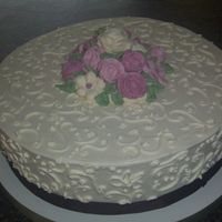 100_1337.jpg Vanilla Buttercream frosting with buttercream flowers in shades of pink. Chocolate brown accent ribbon