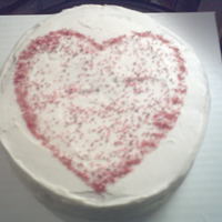 Happy Valentine's Day Red Velvet cake with cream cheese frosting, decorated with a simple heart shape of red sanding sugar