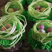 Easter Cupcakes red velvet cupcakes, with cream cheese buttercream for the grass, with sugar nest, and marbleized fondant eggs.