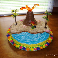 The Laua Cake This idea came from the wilton yearbook. A round cake with buttercream icing. Royal icing flowers around the side of the cake. The water is...