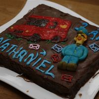 Postman Pat Choc-Cake plain chocolate cake with chocolate frosting, Postman pat car in painted royal icing, Envelopes and writing in colored royal icing and...
