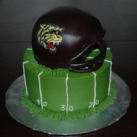 Football Cake Quick football theme cake. Helmet is made our of two 6" and carved, face mask is made with gumpaste.