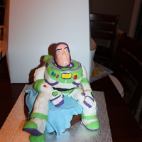Buzz Birthday this is a 10 inch buzz in rice crispies treat and gum paste sit on a fondant blanket on a 9inch chocolat cake. I madi it for the 3 years...