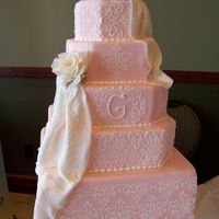 Laced In Pink Pink fondant covered with a lace damask print and drapes of fondant. The Monogram on the center cake adds a nice touch!
