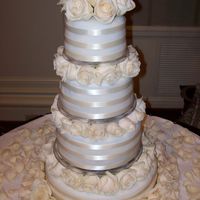 Lover Of Ivory Ivory tiers adorned with Ivory ribbon and roses makes this cake very pure and elegant.