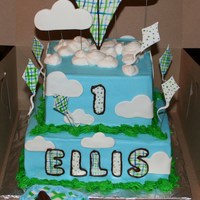 Kites And Clouds 1St Birthday Cake 2 tier square cake. Top is 8 inch Almond Vanilla and bottom is 10 inch strawberry. All iced in Decorators buttercream with fondant details...