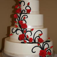 Black And White With Red Roses Buttercream cake with black fondant scrolling, red sugarpaste roses, and a painted fondant border.