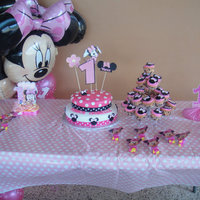 Minnie Mouse 1St Birthday Cake. Cake and cupcakes were almond and brandy flavor. Cake covered in Vanilla fondant and cupcakes frosted with pink buttercream frosting with a...