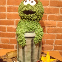 Oscar The Grouch Chocolate & Vanilla Cakes with fudge filling. Decorated in fondant and buttercream. Garbage on the board made of gumpaste, modeling...