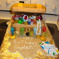 Treasure Chest cake covered in fondant. used rock candy, choc coins, ring pops, and candy necklaces. brown sugar as sand