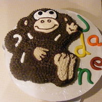 Monkey Birthday Cake white cake with confetti and chocolate butter cream frosting, fondant letters and wilton tube icing for eyes, nose and mouth