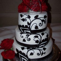 Black And Red Wedding The cake was a red velvet with cream cheese frosting, it covered in white fondant and the black decoration where all done by hand in black...
