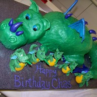 Chas' Dragon Birthday Cake Carved dragon cake. Pebble impression mat textured fondant. Gum paste dragon candle holders. The layers inside the cake were rainbow, tail...