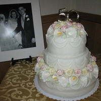 50Th Wedding Anniversary I made this cake with the help of my mom. I'm 16 and the flowers are gumpaste roses and lilly 's- all hand made.