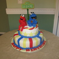 Laughing Elmo And Cookie Monster 1st elmo and cookie monster cake . 2 tier cake bottom tier is a yellow cake walmond buttercream, top tier is a red velvet cake w/cream...