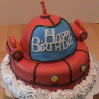 Rocket From Little Einstein's The base of rocket is a two 10 in round cakes and sitting on top is the half ball cake. I just rounded the edges of the 10 in. and frosted...