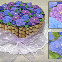 Purple Flowers For Mom's Birthday Sides are covered in chocolate hazelnut rolled wafer cookies cut to size. Flowers are royal icing covered in copious amounts of pearl dust...