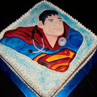 Super Medic Superman fondant relief with fondant stethoscope around his neck. SUPER MEDIC. Placed on a 12" square cake covered in buttercream.