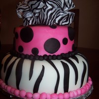 Sweet 16 Zebra Fondant covered cake. Zebra print on bottom layer and fuschia and black dots on top tier zebra print ribbon as topper