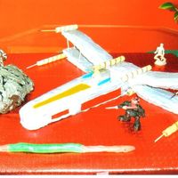 X Wing Fighter Plane Body of plane is chockolate, the wings are made of rice krispy treats, the hill was just left over cake.