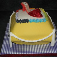 Oz Pillow Cake A modern spin on Dorothy and her ruby slippers. Gumpaste shoe with Disco Dust, rainbow fondant flower trim, brick impression mat used on...