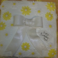 Daisy Cake 12' yellow cake with marzipan filling and covered in MMF. Bow , daisies and gift tag all gumpaste.