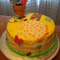 Mother's Day Garden Cake 2 layer, 9 inch round cake. Yellow buttercream icing and grass icing border. All garden decorations are made out of fondant, except the...