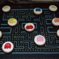 Pac Man Cupcakes Brief was retro games in cake so came up with this idea.Iced board and marked out game then using cupcakes made the Pac man, ghosts etc.
