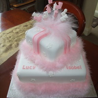 Baby Girl Christening Cake 2 Tier stacked square cakes (10" & 6") decorated with ribbon parcel effect on top tier and small flat blossoms on both cakes...