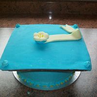 Blue And Yellow Single Flower Graduation Cake Chocolate top covered in fondant with a royal iced cake modelled with fondant ribbon and a single pressed flower x