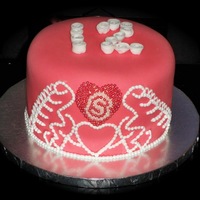 Pink Tiara Cake covered in pink fondant with white fondant rosettes. Freehand royal icing tiara. Heart is made from dragees.