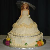 Bride In Ivory Wonder Mold doll atop a large petal-shaped cake. Ivory buttercream with royal flowers (in Fall colors).