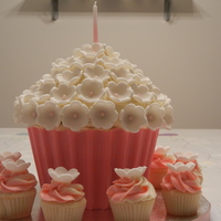 Giant Flower Cupcake White chocolate raspberry cake with white chocolate buttercream. Candy liner with fondant flowers.