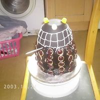 Dalek I ended up having to use 6 layers of chocolate sponge cake to get the right height for this and a large amount of black sugar paste!! but...