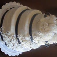 Sandra's Mini 3-Tier Cake 6", 5" and 4" gloden vanilla tiers with bavarian creme filling and buttercreme icing. Fondant roses and five-petal flowers...