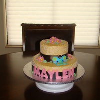 Maylen Beige buttercream with white piping accented with fondant flowers and butterfly.