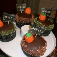 Halloween Cupcakes Chocolate cupcakes with Chocolate icing, orange and green sugar with candy corn pumpkins.