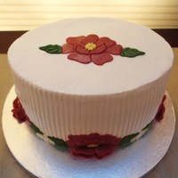 Rose Birthday Cake This is a small oval cake iced in buttercream. The roses were made using an open rose patchwork cutter and brushed with luster dust.