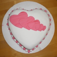 Valentine's Day Cake Fondant covered chocolate cake with chocolate genache & buttercream. Fondant decorations on heart shaped cake.